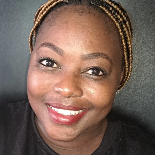 Smiling client with permanent eyeliner and deep skin