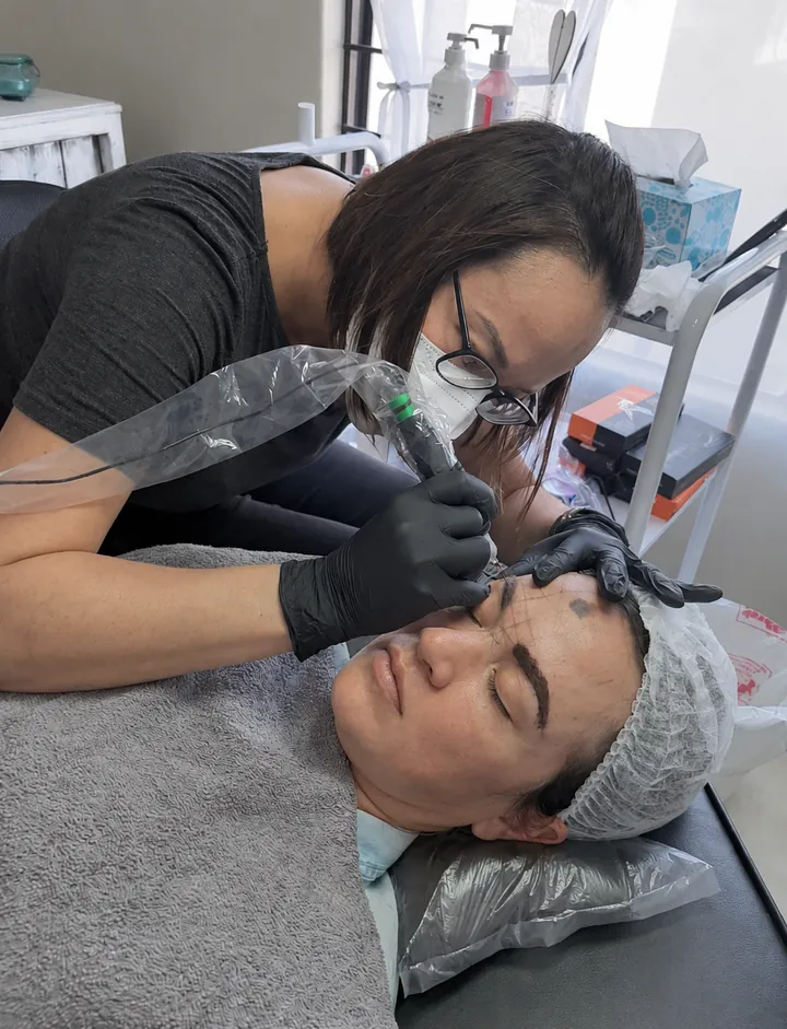 PMU student doing brows on a model during one-to-one training in Tess's Pretoria East studio